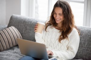 a young woman using laptop while having coffee