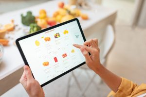a female using smart devices with fruits and vegetables